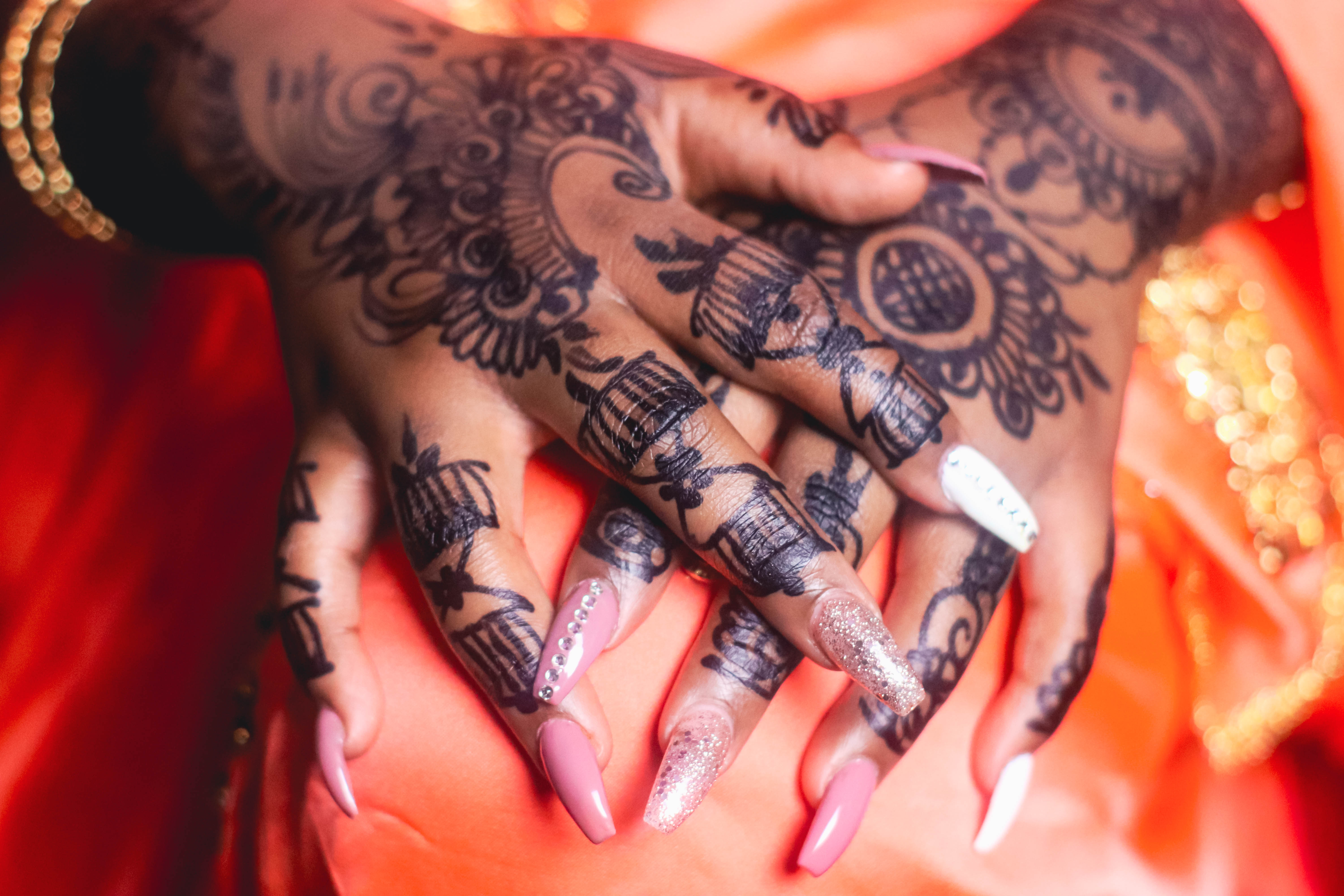 A photograph of a woman's hands showing off her henna designs.